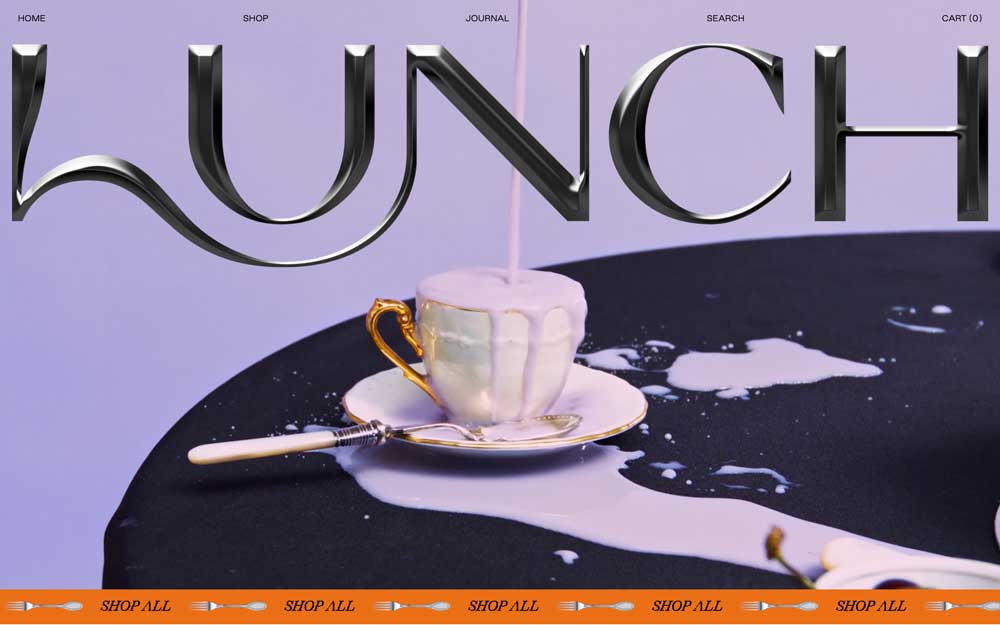 Screenshot of a website. The word “Lunch” appears large, in all-caps, superimposed over a photo of an ornate coffee cup overflowing with cream. Below, an orange banner shows the words “Shop All” and a fork, tiled horizontally.